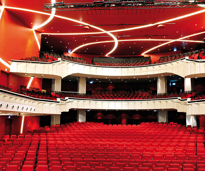 Αίθουσα εκδηλώσεων με κόκκινα καθίσματα και οροφή με Acoustic-Lightboard