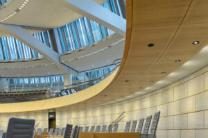 Acoustic lightboard με καμπύλες ξύλινες επιφάνειες και ενσωματωμένο φωτισμό σε σύγχρονο εσωτερικό χώρο